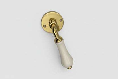 Door handle with gold metal and white ceramic handle on a black background